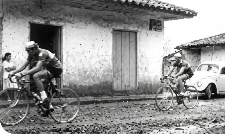Ciclistas atravesando un pueblo en una de las primeras Vueltas a Colombia
